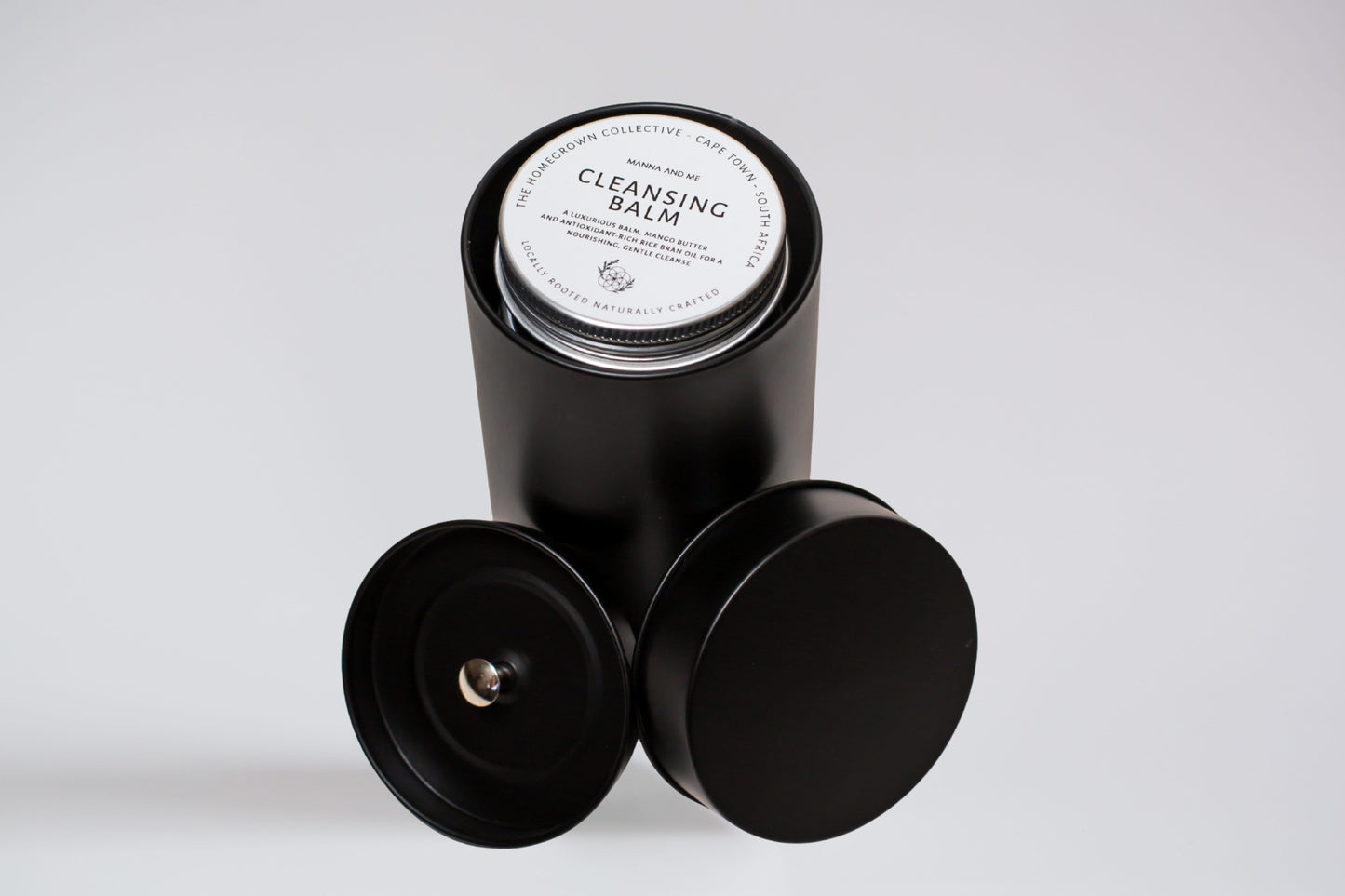 Manna and Me Ritual Discovery Set featuring four travel-size tins of natural skincare balms and creams.