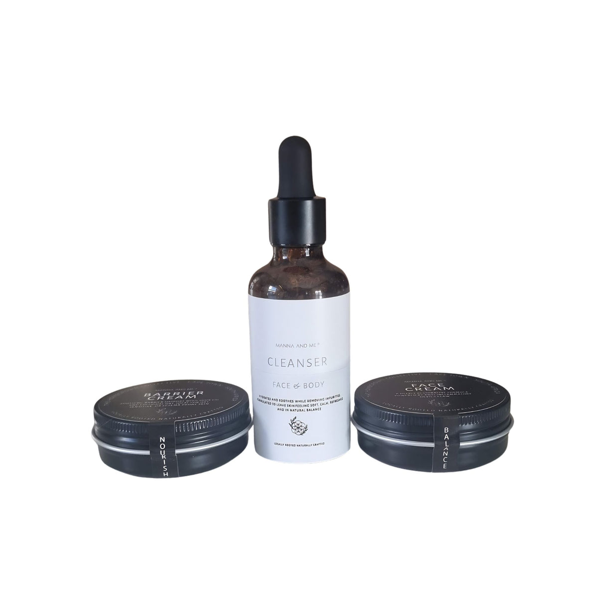 A skincare set featuring a central amber glass dropper bottle labeled 'CLEANSER FACE & BODY' with a white label, flanked by two black metal tins on a plain white background, containing a 40ml barrier cream and 40ml face cream respectively.