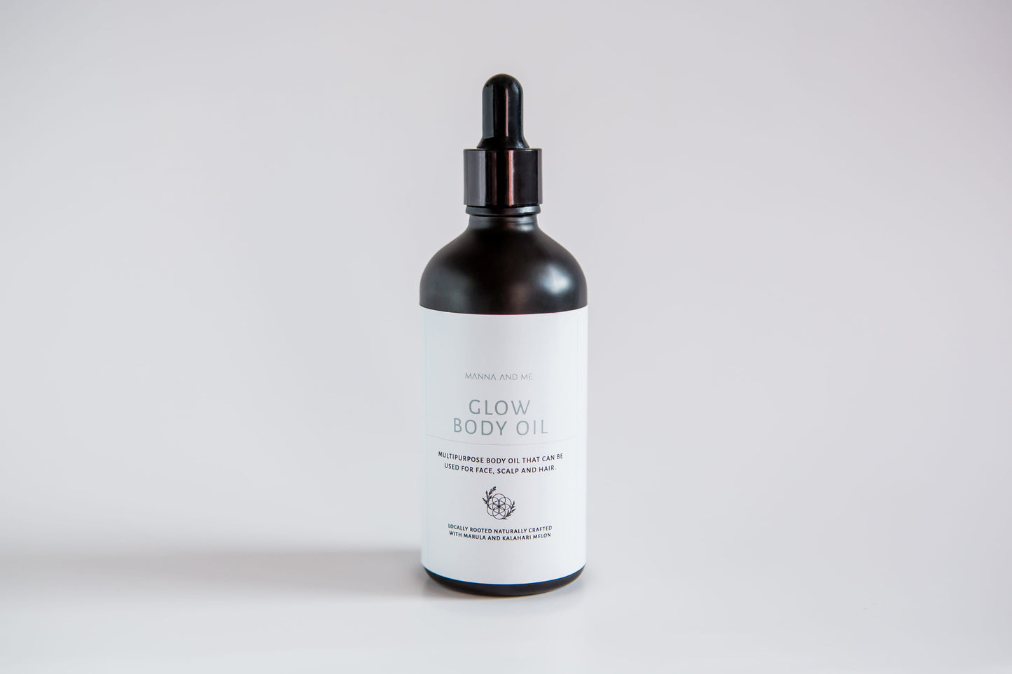 Manna and Me Glow Body Oil bottle, luxurious radiant skin hydration infused with botanical botanical extracts.