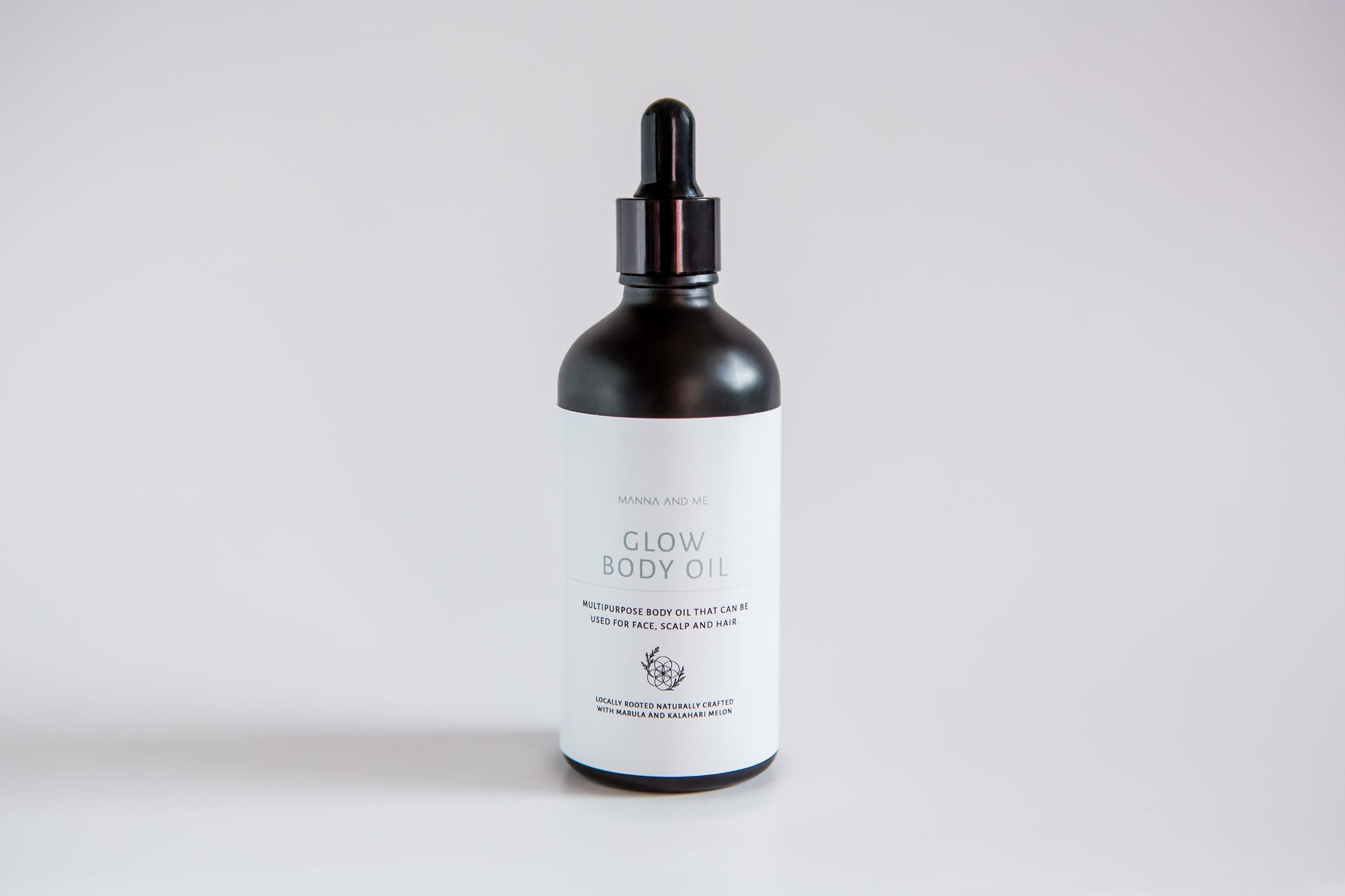 Manna and Me Glow Body Oil bottle, luxurious radiant skin hydration infused with botanical botanical extracts.