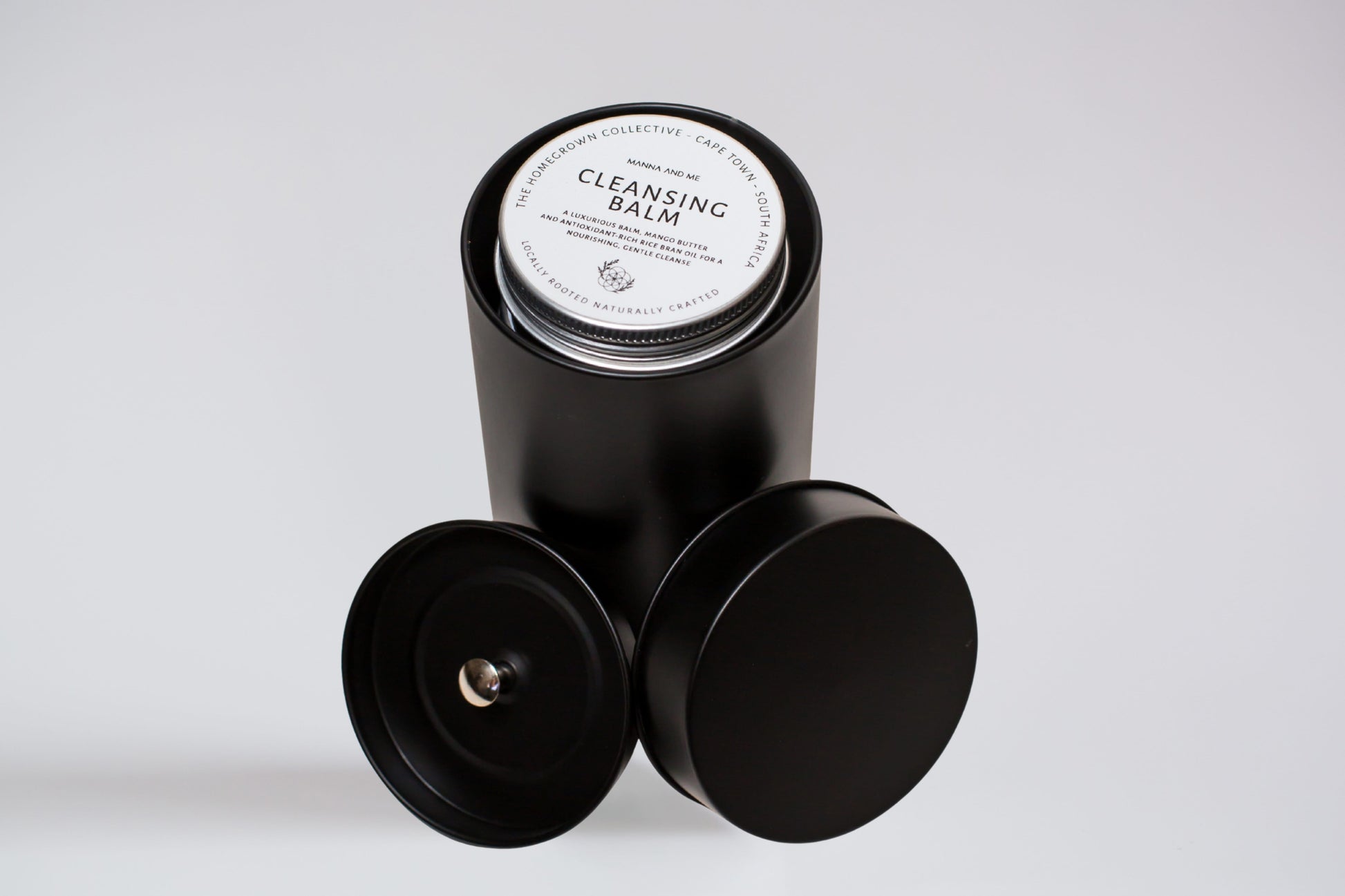 Manna and Me Ritual Discovery Set featuring four travel-size tins of natural skincare balms and creams.